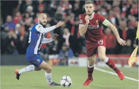  ??  ?? Liverpool’s former Sunderland midfielder, Jordan Henderson, battles it out with Porto’s Andre Andre in last night’s Anfield draw.