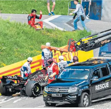  ?? CHIRISTIAN BRUNA / EFE ?? Carlos Sainz observa desde un montículo cómo retiran su monoplaza, que salió ardiendo por un fallo en el motor.