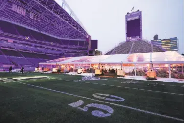  ?? Ted S. Warren / Associated Press ?? Guests eat dinner prepared by local chefs on Feb. 18 in an outdoor tent set up at Lumen Field, the home of the Seattle Seahawks NFL team. The Field to Table pandemic dining series is running through March.