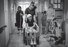  ?? Efrem Lukatsky/Associated Press ?? A nurse pushes a wheelchair carrying a woman wounded in a deadly Russian airstrike on a mall in Kremenchuk, Ukraine.