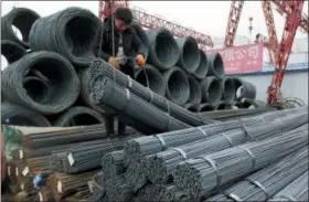  ?? THE ASSOCIATED PRESS ?? A worker loads steel products onto a vehicle at a steel market in Fuyang in central China’s Anhui province Friday.