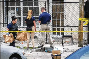  ?? LANNIS WATERS / THE PALM BEACH POST ?? West Palm Beach police investigat­e a shooting on North Sapodilla Avenue near Seventh Street that left one man dead and another in the hospital Thursday.