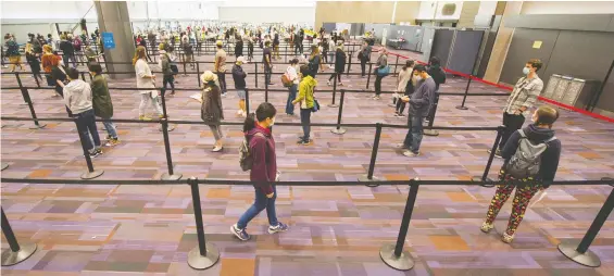  ?? ARLEN REDEKOP ?? People line up Monday for COVID shots at the Vancouver Convention Centre. B.C. has administer­ed over two million doses.