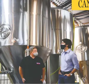  ?? SEAN KILPATRICK / THE CANADIAN PRESS ?? Justin Trudeau talks with Big Rig’s Lon Ladelly in Ottawa on Friday. The brewery is helping to make hand sanitizer.