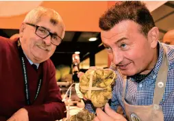  ??  ?? Davide Curzietti (right) shows off a 730-gram truffle to judge Natale Romagnolo at the Alba Truffle Fair. — Photos by IC