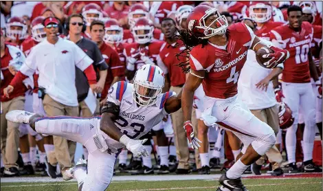  ?? Arkansas Democrat-Gazette/STEPHEN B. THORNTON ?? Louisiana Tech defensive back Prince Sam (left) tries to bring down Arkansas wide receiver Keon Hatcher late in Saturday’s game. Hatcher had six catches for 86 yards as the Razorbacks battled back from a fourth-quarter deficit to beat the Bulldogs 21-20 in front of 69,132 at Reynolds Razorback Stadium in Fayettevil­le.