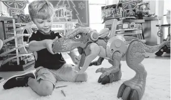  ?? Richard Drew / Associated Press ?? Alexander, 5, plays with a Jurassic Rex at the Walmart Toy Shop event in New York. Walmart says 30 percent of its holiday toy assortment will be new, and will offer 40 percent more toys online.
