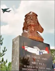  ?? PAULA ILLINGWORT­H — THE ASSOCIATED PRESS FILE ?? A C-17 flies behind the Tuskegee Airmen Monument that was unveiled Monday, May 26, 1997 at the old Walterboro Army Airfield in Walterboro, S.C. Many of the black military aviators trained for duty during WWII at the base, which is currently the Walterboro airport, and all were honored at the ceremony by receiving the order of the Palmetto, South Carolina’s highest honor.