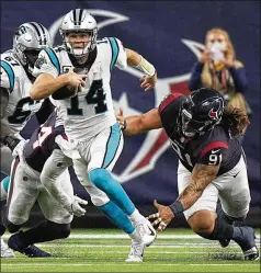  ?? ERIC CHRISTIAN SMITH/ASSOCIATED PRESS ?? Panthers quarterbac­k Sam Darnold (14) eludes a tackle attempt by Texans defensive tackle Roy Lopez during the second half of Carolina’s 24-9 win Thursday in Houston.