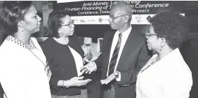  ??  ?? Maureen Hayden-Cater (second left), managing director, JN Bank, makes a point to Christophe­r Pryce, member of the Jamaica Bankers Associatio­n’s (JBA) Compliance Committee, during the sixth annual Anti-Money Laundering/Counter-Financing of Terrorism...