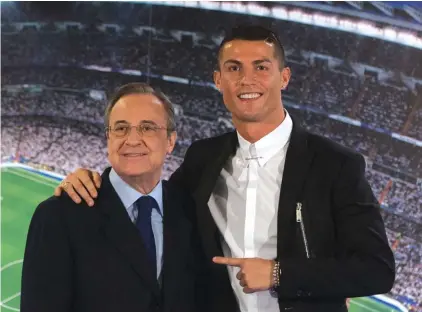  ??  ?? Real Madrid’s Cristiano Ronaldo, right, poses with Real Madrid President Florentino Perez after signing a new contract yesterday Photo: AP