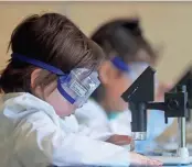  ?? ?? Iden Pelky, left, and Cora Powless use microscope­s in The Lab.