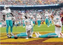  ?? Daniel Kucin Jr./Associated Press ?? Miami’s Tyreek Hill (10) pretends he’s on a roller coaster as he celebrates a touchdown in the Dolphins’ victory over Washington Sunday.