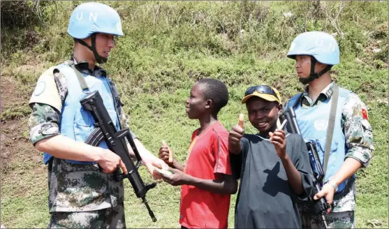  ?? PROVIDED TO CHINA DAILY ?? Chinese peacekeepe­rs talk with local children during a patrol in the Democratic Republic of the Congo.