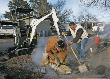  ?? LUKE E. MONTAVON/THE NEW MEXICAN ?? Workers with C. Smith Constructi­on Co. labor Friday to fix an emergency gas leak at the Country Club Gardens Mobile Home Park.