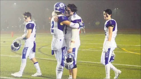  ?? Christian Abraham / Hearst Connecticu­t Media ?? Darien’s Austin Dehmel (2) and teammate Grayden Overbeck (71) embrace after the team was defeated by Newtown in the CIAC Class LL Championsh­ip in Trumbull on Saturday. Newtown won, 137.