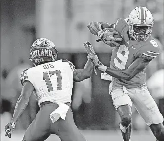  ?? [KYLE ROBERTSON/ DISPATCH] ?? Receiver Binjimen Victor slips past Maryland defensive back Tino Ellis after making one of his four catches in last week’s game. The sophomore finished with 55 yards and a touchdown.