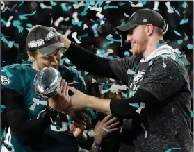  ?? AP Photo/Frank Franklin II ?? National Champions: In this Feb. 4, 2018 photo, Philadelph­ia Eagles quarterbac­k Carson Wentz, right, hands the Vincent Lombardi trophy to Nick Foles after winning the NFL Super Bowl 52 football game against the New England Patriots in Minneapoli­s. The...