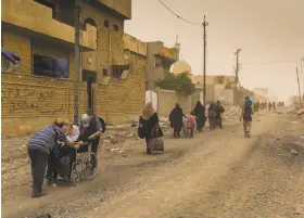  ?? Ivor Prickett / New York Times ?? People leave the besieged city of Mosul, Iraq, amid a sandstorm last month. The United Nations accuses Islamic State militants of slaughteri­ng civilians.