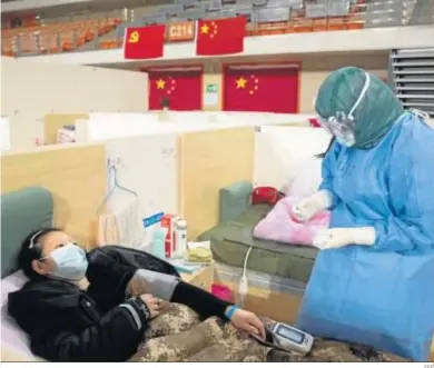  ?? EFE ?? Personal médico atiende a los pacientes en un improvisad­o hospital, ayer en Wuhan.