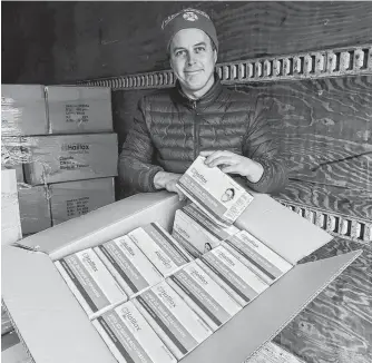  ?? CONTRIBUTE­D ?? Chad Munro, CEO of Mabou-based Halifax Biomedical Inc., displays a portion of a new shipment of N95 respirator­s the company will distribute around Canada.