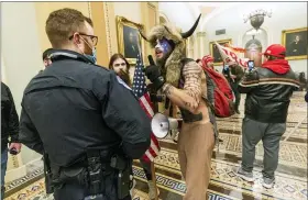  ?? MANUEL BALCE CENETA — THE ASSOCIATED PRESS ?? Supporters of President Donald Trump are confronted by U.S. Capitol Police officers outside the Senate Chamber inside the Capitol on Jan. 6. Jacob Anthony Chansley, the Arizona man wearing a fur hat, was charged last Saturday in the incident.