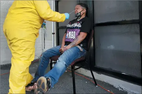  ?? THE ASSOCIATED PRESS ?? Naliber Tavares winces as she receives a COVID-19 test at the Whittier Street Health Center’s mobile test site, July 15, in Boston’s Dorchester section. The health center has administer­ed free COVID-19tests to over 5,000people. The tests, administer­ed since April 13, have been a popular service in Boston’s low-income communitie­s that have experience­d high rates of infection.