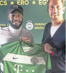  ??  ?? Zyen Jones (left) poses with a member of staff of Hungarian champions Ferencváro­si TC after signing a contract with the club on Tuesday.