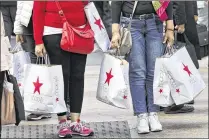  ?? BEBETO MATTHEWS / ASSOCIATED PRESS ?? Shoppers holding Macy’s bags wait to cross an intersecti­on in New York City earlier this month. Consumer spending in April rose 0.4 percent, the Commerce Department said, in what was the fastest pace in four months.