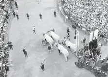  ?? RICK STEVES ?? The crowd looks on as an oxen cart pulls the Palio banner through Siena's main square.