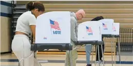  ?? BRIAN KRISTA/BALTIMORE SUN MEDIA ?? Voters fill out their ballots at the polling place at Marriotts Ridge High on Election Day.