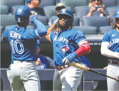  ?? WENDELL CRUZ/USA TODAY SPORTS ?? Toronto second baseman Marcus Semien is greeted by first baseman Vladimir Guerrero Jr. after hitting a solo home run in the first inning against New York at Yankee Stadium on Monday. Semien homered twice in the Jays' win, and Guerrero hit his 40th.
