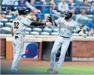  ?? ELSA/GETTY IMAGES ?? Miami’s Derek Dietrich, left, and Miguel Rojas celebrate after they score in the second inning against the New York Mets at Citi Field on Tuesday night. The Marlins built up a lead and held on to defeat the Mets, 5-1.