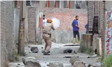  ?? MUKHTAR KHAN, AP ?? An Indian policeman fires tear gas at Kashmiri protesters after the funeral Wednesday of local rebel Aqib Ahmad in Srinagar, in Indian-controlled Kashmir. Protests erupted after three Kashmiri rebels died in a gun battle with government forces.