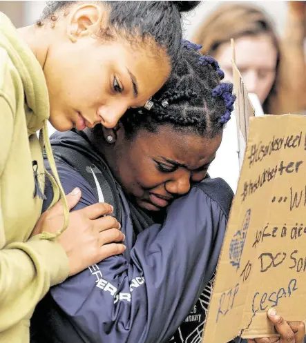  ?? Godofredo A. Vásquez / Staff photograph­er ?? Laila Geers, left, consoles Jasmin McGee while a fellow Bellaire High School student speaks Friday about 19-year-old Cesar Cortes, who was shot and killed Tuesday at the school. The students held a silent sit-in outside the Houston ISD headquarte­rs.