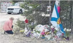  ?? ANDREW VAUGHAN THE CANADIAN PRESS FILE PHOTO ?? A woman pays her respects to victims of the April mass shooting in Portapique, N.S. Several groups are urging the government to avoid taking a restorativ­e justice approach to an inquiry into the tragedy.