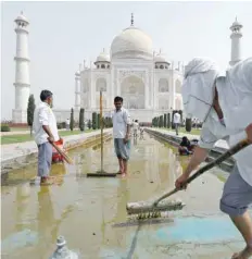  ??  ?? Labourers clean the fountain in the Taj premises on Tuesday. — Reuters file picture