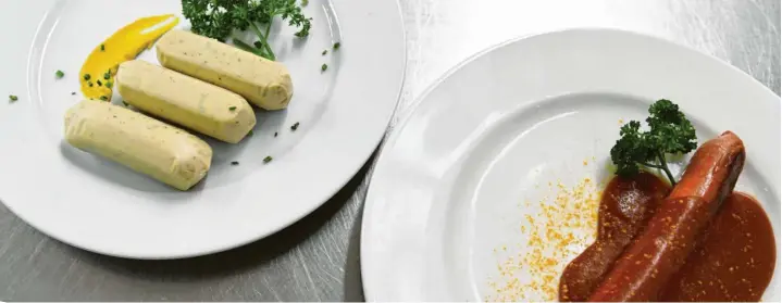  ?? Foto: Felix Hörhager, dpa ?? Eine vegane Currywurst und vegane Weißwürste liegen auf Tellern an der Essensausg­abe im Hofbräuzel­t auf dem Oktoberfes­t.