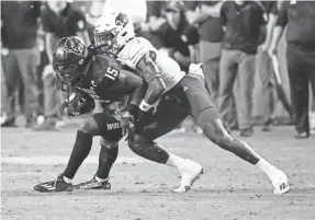  ?? KARL B DEBLAKER/AP ?? North Carolina State’s Keyon Lesane (15) is stopped by Louisville’s Jarvis Brownlee Jr. (2) during the first half of their Sept. 29 game in Raleigh, N.C..