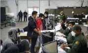  ?? AP PHOTO/DARIO LOPEZ-MILLS,POOL ?? Migrants are processed at the intake area of the Donna Department of Homeland Security holding facility, the main detention center for unaccompan­ied children in the Rio Grande Valley, in Donna, Texas, Tuesday, March 30, 2021.