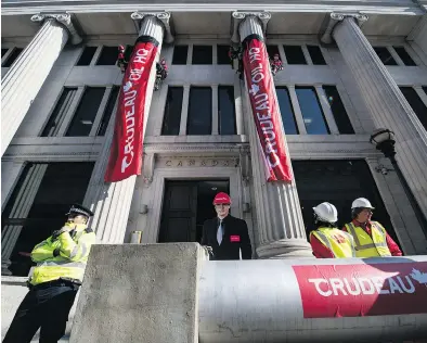  ?? TOLGA AKMEN / AFP / GETTY IMAGES ?? Protesters use a mock pipeline labelled ‘Crudeau Oil’ to block the entrance to Canada House in London on Wednesday.