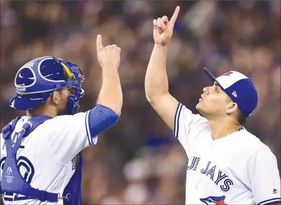  ?? The Canadian Press ?? Toronto Blue Jays catcher Luke Maile, left, and pitcher Roberto Osuna celebrate their 7-5 victory over the New York Yankees in AL action on Friday in Toronto.