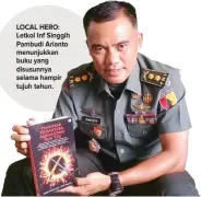  ?? SURYO EKO PRASETYO/JAWA POS ?? LOCAL HERO: Letkol Inf Singgih Pambudi Arianto menunjukka­n buku yang disusunnya selama hampir tujuh tahun.