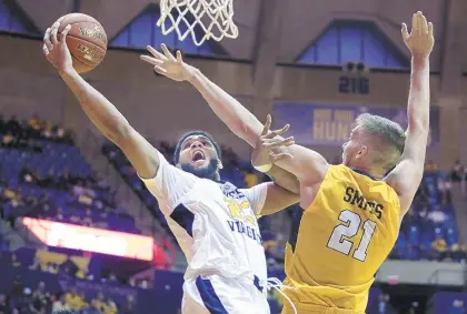  ?? RAYMOND THOMPSON/THE ASSOCIATED PRESS ?? West Virginia forward Esa Ahmad drives to the basket while being defended by Valparaiso center Derrik Smits on Saturday in Morgantown, W.Va.