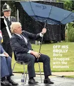  ??  ?? OFF HIS BROLLY Boris struggles with the elements