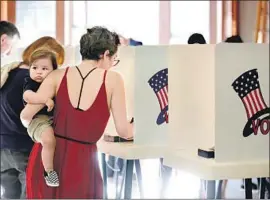  ?? Francine Orr Los Angeles Times ?? RACHEL MESA, with son Madison, casts her vote on Nov. 6, 2018, in Stevenson Ranch. California’s cybersecur­ity enforcemen­t is among the nation’s strictest.