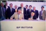  ?? PROVIDED TO CHINA DAILY ?? Indiana Governor Eric Holcomb and John Zhang, CEO of SF Motors, sign papers on May 30 for SF to begin renovating the former AM General plant in Mishawaka to make electric vehicles. SF expects to employ 467 at the facility by 2020.