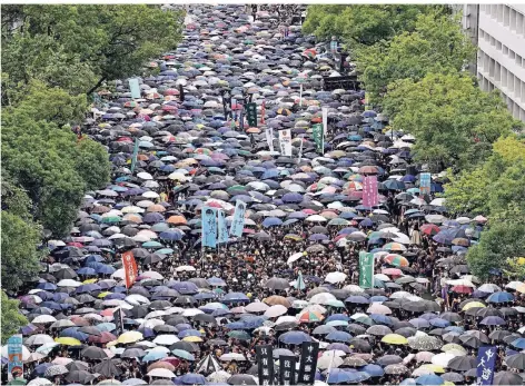  ?? FOTO: DPA ?? Regenschir­me gegen Videokamer­as: Studenten der Chinesisch­en Universitä­t Hongkong streiken nach dem Ende der Ferien.