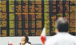  ??  ?? TRADERS look at an electronic board at the Philippine Stock Exchange (PSC) in Manila on July 14, 2011.