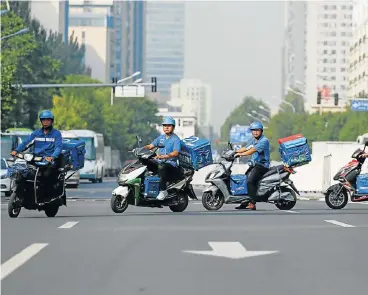  ?? /Reuters ?? Food on the move: Ele.me drivers head into Beijing’s traffic en route to deliver food to customers. The start-up company has been bought by Alibaba as part of the online behemoth’s plans to expand into the growing delivery market.